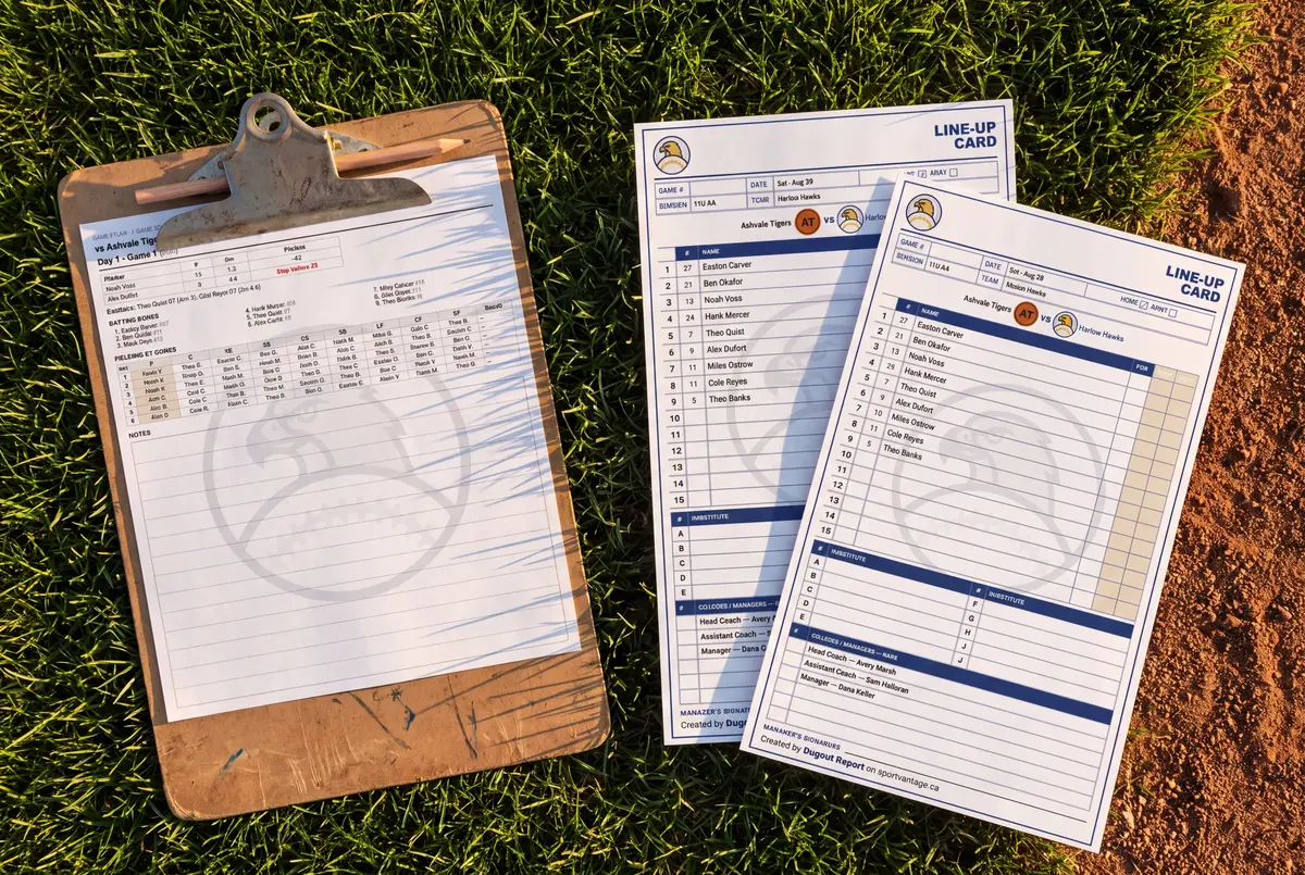 A clipboard on the field grass holding a printed game plan, with two printed line-up cards beside it